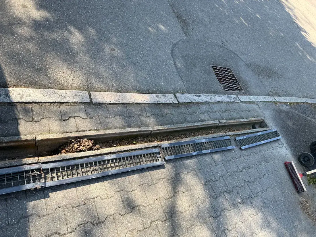 Vorher: mit Laub und Schmutz verstopfte Entwässerungsrinne vor einer Wohnanlage in Reutlingen
