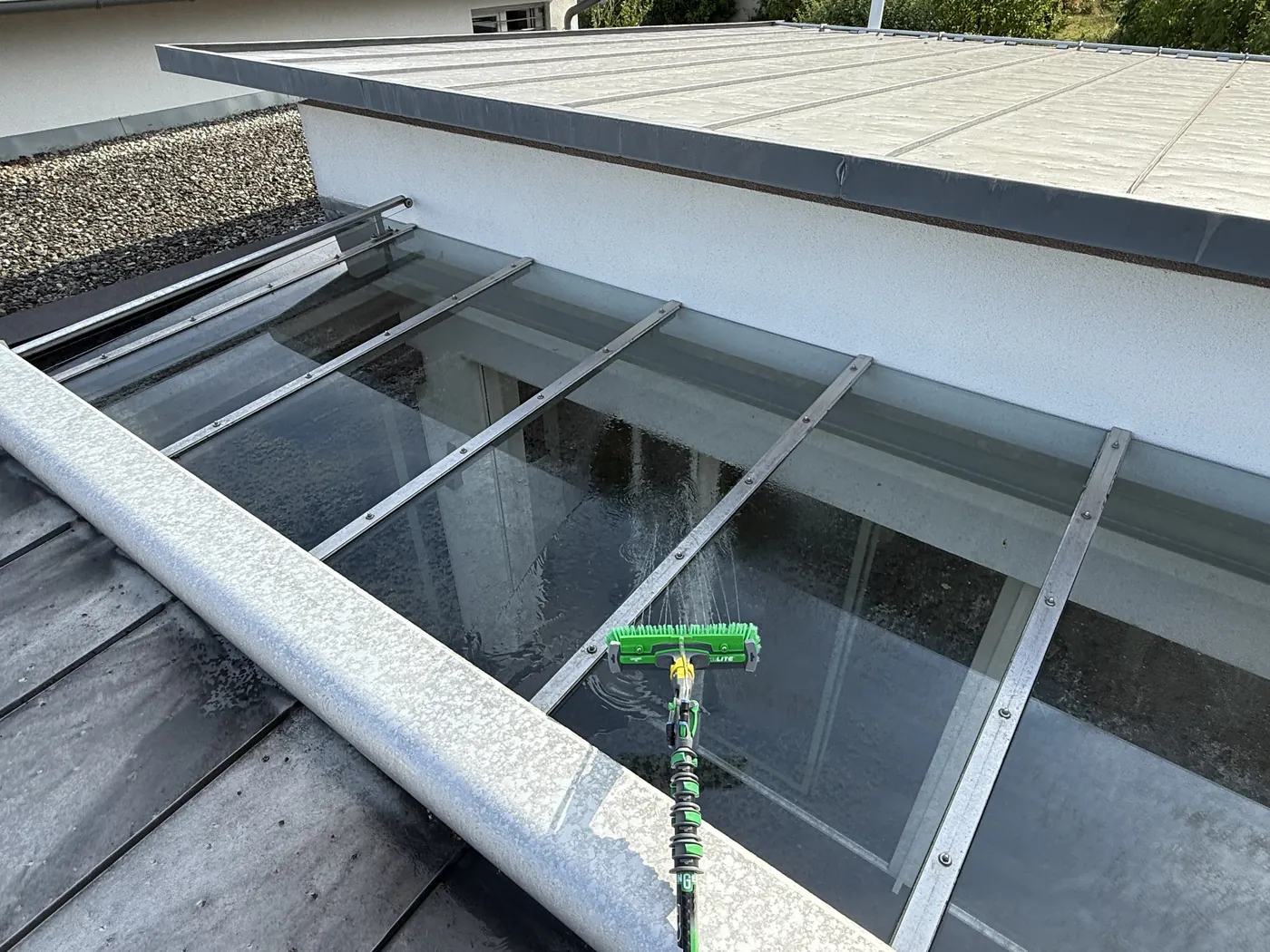 Glasvordach wird mit Reinstwasser und Teleskopstange gereinigt