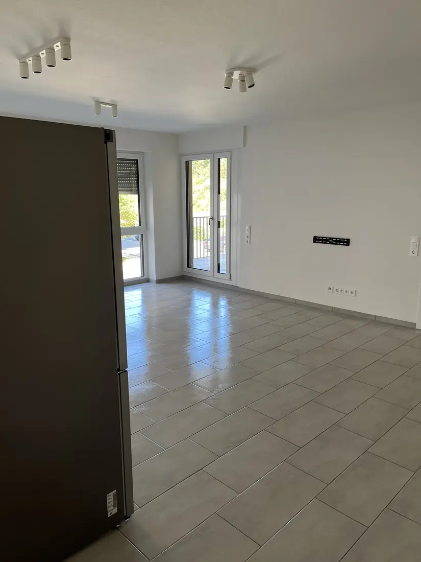 Grundgereinigter, leerer Wohnraum mit glänzendem Fliesenboden vor der Wohnungsübergabe