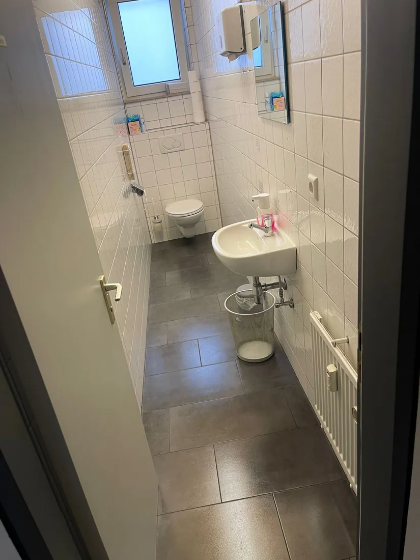 Sanitärreinigung in einem Büro in Reutlingen: gereinigtes WC mit Waschbecken und Fliesenboden
