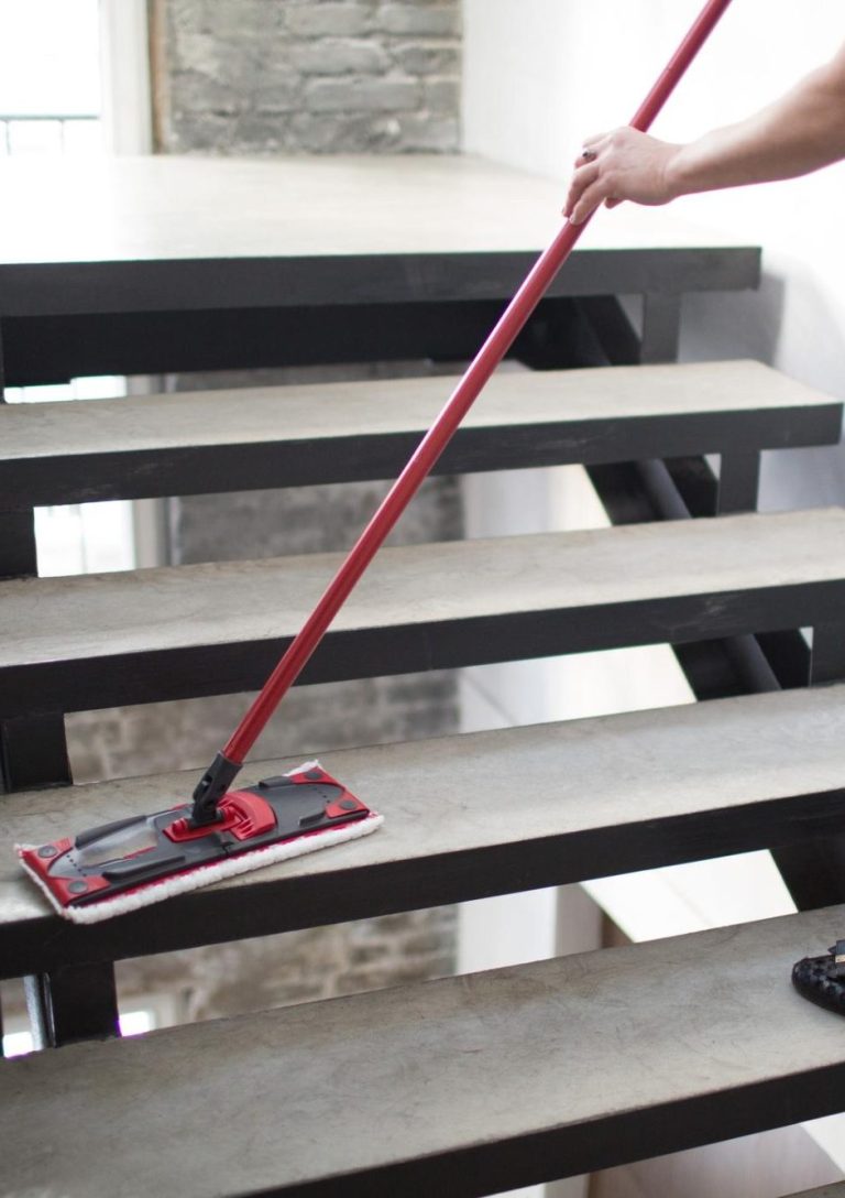 Professionelle Treppenhausreinigung in Reutlingen – Reinigungskraft wischt Treppen in Bürogebäude